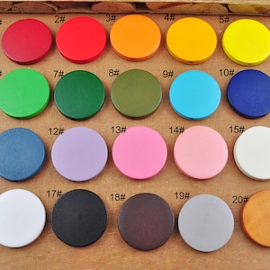 May include: Twenty wooden circles in various colors, numbered 1 through 20. The circles are arranged in rows of five, with each row containing a different color.