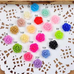 May include: Twenty assorted plastic rose flower embellishments in various colors, including pink, red, blue, green, yellow, and purple. Each flower is numbered 1 through 20.