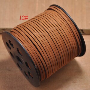 Puede incluir: Una bobina de cordón de cuero marrón, enrollada alrededor de una bobina de plástico negro con agujeros. El cordón está etiquetado con "12#" en la bobina.