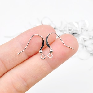 May include: Two silver earring hooks with a small ball at the end of each hook.
