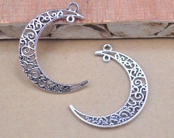 May include: Two silver filigree crescent moon charms with a loop at the top for hanging.