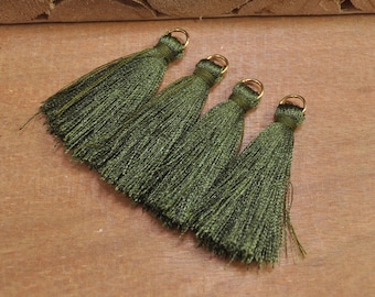May include: Four green tassel trim with gold metal rings.