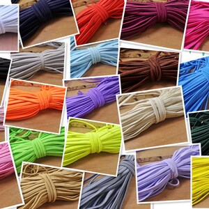 Könnte beinhalten: Eine Collage aus farbigen elastischen Kordeln in verschiedenen Farbtönen, darunter Weiß, Schwarz, Grau, Blau, Orange, Lila, Rosa, Grün, Braun und Gelb. Jede Kordel ist gebündelt und vor einem neutralen Hintergrund präsentiert, um die Farbpalette zu zeigen.