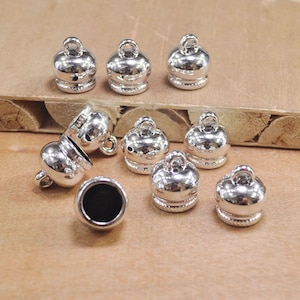 May include: Silver metal end caps for jewelry making. The caps are round and have a smooth, shiny finish. They are perfect for adding a touch of elegance to your jewelry designs.