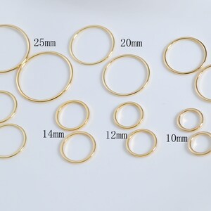 May include: Assortment of gold jump rings in various sizes, ranging from 10mm to 25mm.  The jump rings are arranged in rows on a white background.