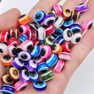 May include: A collection of colorful plastic beads with an evil eye design. The beads are in various shades of blue, green, red, yellow, and purple.