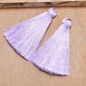 May include: Two lavender silk tassels with a frayed edge.