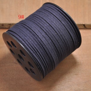Puede incluir: Una bobina de cordón de ante azul oscuro, etiquetada con "9#", enrollada alrededor de una bobina de plástico negro con agujeros.