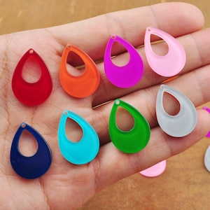 Puede incluir: Surtido de abalorios de acrílico de forma de lágrima de colores con un agujero en la parte superior. Los abalorios son de varios colores, incluyendo rojo, naranja, rosa, morado, verde, azul y blanco.