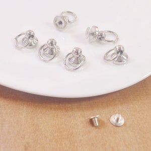 Peut inclure: Ferrures en métal argenté avec un anneau et une vis, base ronde et un petit anneau sur le dessus.