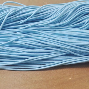 Könnte beinhalten: Nahaufnahme eines Stapels hellblauer Gummikordel. Die Kordel ist weich und flexibel und perfekt für Bastelprojekte.