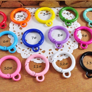 May include: Thirteen colorful metal key rings with a spring-loaded clasp. The key rings are numbered 1 through 13.