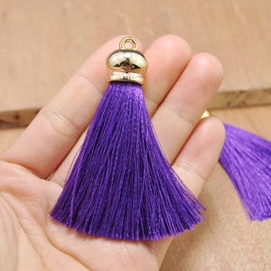 May include: Purple silk tassel with a gold metal top. The tassel is about 2 inches long.