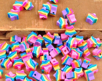 Può includere: Un vasto assortimento di perline colorate a forma di stella con strisce arcobaleno. Le perline sono in plastica e hanno un foro al centro per essere infilate.
