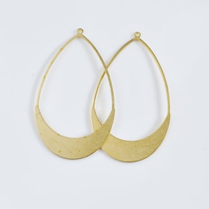 Puede incluir: Dos pendientes de aro de metal dorado con forma de media luna. Los pendientes son simples y elegantes.