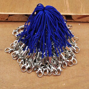 May include: A bunch of blue string keychains with silver lobster claw clasps.