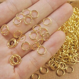 Puede incluir: Un mont&oacute;n grande de anillos de salto dorados. Los anillos son peque&ntilde;os y delicados, y son perfectos para la elaboraci&oacute;n de joyas.