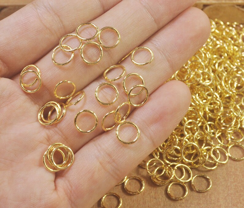 Puede incluir: Un mont&oacute;n grande de anillos de salto dorados. Los anillos son peque&ntilde;os y delicados, y son perfectos para la elaboraci&oacute;n de joyas.