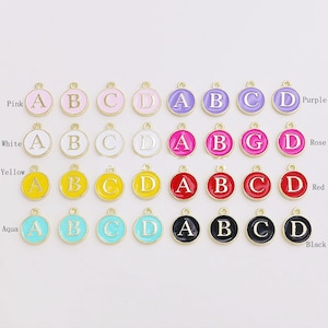 Può includere: Assortimento di 16 ciondoli con lettere smaltate in vari colori, tra cui rosa, bianco, giallo, acquamarina, rosso, viola e rosa. Ogni ciondolo presenta una lettera dorata A, B, C, D o G.