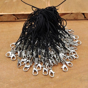 Può includere: Un pacchetto all'ingrosso di ciondoli per telefono in corda nera con moschettoni argentati.