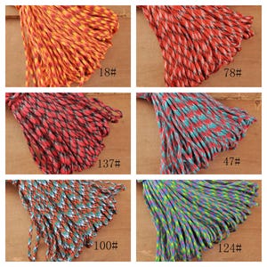 May include: A collection of colorful paracord bundles in various patterns and shades, including orange, red, teal, and blue. Each bundle is labeled with a number, such as "18#" and "78#", indicating a specific type or color.