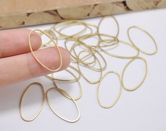 Può includere: Un mucchio di anelli ovali in metallo dorato. Gli anelli sono lisci e hanno una finitura lucida.