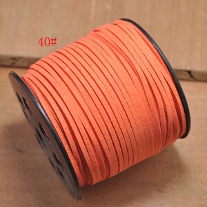 May include: A spool of bright orange suede cord, wound around a black plastic bobbin. The cord is labeled "40#"