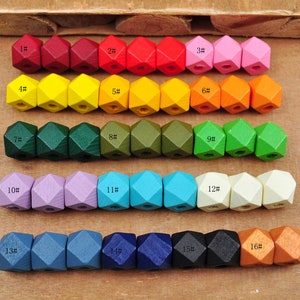 May include: A set of 16 wooden beads in various colors, each bead is a 12-sided geometric shape. The beads are numbered 1 through 16.