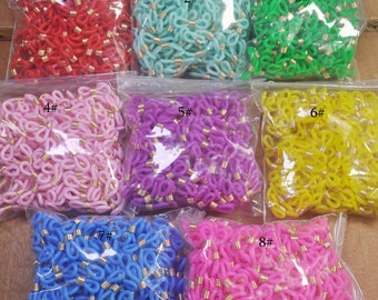 Può includere: Otto sacchetti di maglie di catena in plastica colorata con accenti in metallo dorato. I sacchetti sono etichettati con i numeri da 1 a 8.