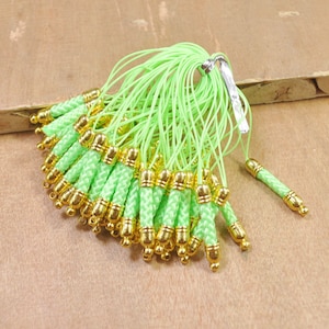 Puede incluir: Un paquete a granel de 30 llaveros de cordón verde y dorado. Cada llavero tiene un cordón verde trenzado con una tapa de metal dorada.