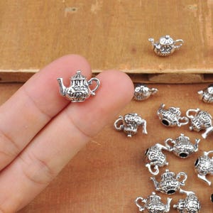 May include: Silver teapot charms with intricate details. The charms are ideal for adding a touch of vintage charm to jewellery projects.