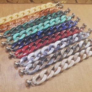 May include: Assortment of colorful plastic chain links, each with a silver metal clasp. The chains are in various colors, including white, gray, brown, red, blue, green, and orange.