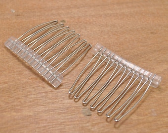 May include: Two silver hair combs with clear plastic bases. The combs have a curved shape and are designed for holding hair in place.