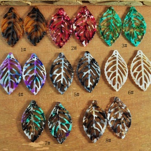 May include: A selection of leaf-shaped pendants in diverse colours, such as brown, red, green, purple, and white. Each pendant features an intricate, open-work design. The pendants are labelled 1# to 8#.