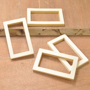 May include: Four unfinished wooden picture frames of various sizes on a wood surface.