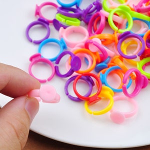 May include: A collection of colorful plastic rings with a white center. The rings are arranged in a pile on a white plate.