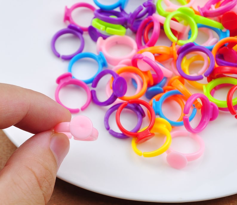 May include: A collection of colorful plastic rings with a white center. The rings are arranged in a pile on a white plate.