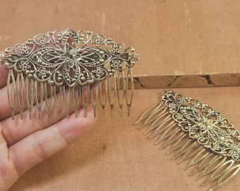 May include: Two gold metal hair combs with intricate floral designs. The combs have a decorative, filigree pattern and are ideal for adding a touch of elegance to any hairstyle.