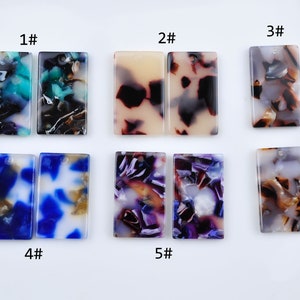 Puede incluir: Diez piezas rectangulares de resina acrílica con diferentes patrones abstractos en tonos de azul, marrón, blanco, morado y crema. Las piezas están etiquetadas del 1# al 5#.