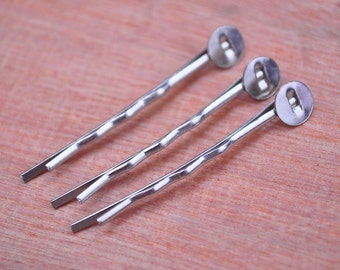 Può includere: Tre fermagli per capelli argentati con estremità rotonde e decorative argentate.
