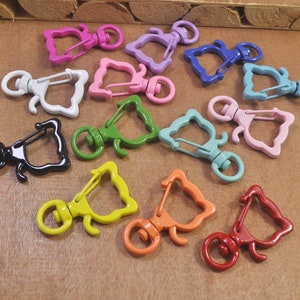 May include: Assortment of colorful metal keychains with a variety of shapes and designs. Each keychain features a unique animal silhouette and a spring-loaded clasp.