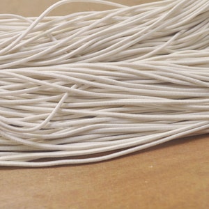 Könnte beinhalten: Nahaufnahme eines Stapels weißen Gummibands. Das Band ist weich und flexibel und perfekt für Bastelprojekte.