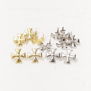 May include: A set of 10 metal cross-shaped studs, with 5 gold and 5 silver studs. The studs have a pointed back for easy attachment.