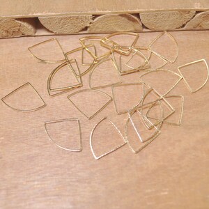 May include: A pile of gold-colored metal half-circle shapes, likely for jewelry making.