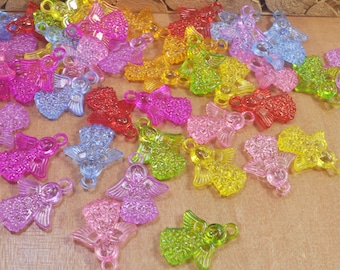 May include: Assortment of colorful plastic angel charms with intricate details. The charms are translucent and feature a variety of colors, including pink, blue, green, yellow, and red.