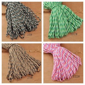 May include: Four bundles of colorful rope. Top left is dark green and brown, labeled 34#. Top right is green and white, labeled 107#. Bottom left is brown and tan, labeled 25#. Bottom right is pink, white, and purple, labeled 122#.