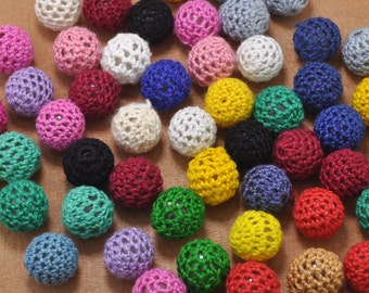 May include: A collection of crocheted balls in various colors, including pink, blue, green, yellow, and white. The balls are made with a delicate, open-stitch pattern.