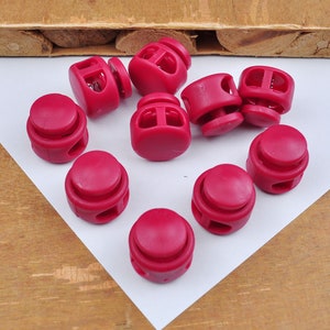 Può includere: Dieci chiusure a scatto in plastica rossa, anche conosciute come fermacavo, da utilizzare per abbigliamento, borse o altri progetti.
