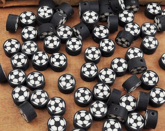 Può includere: Una collezione di perline in ceramica a forma di pallone da calcio, nere e bianche. Le perline hanno una finitura lucida.