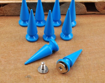 Puede incluir: Diez puntas de plástico azul en forma de cono con base de tornillo. Se muestran dos puntas adicionales con sus bases de tornillo.